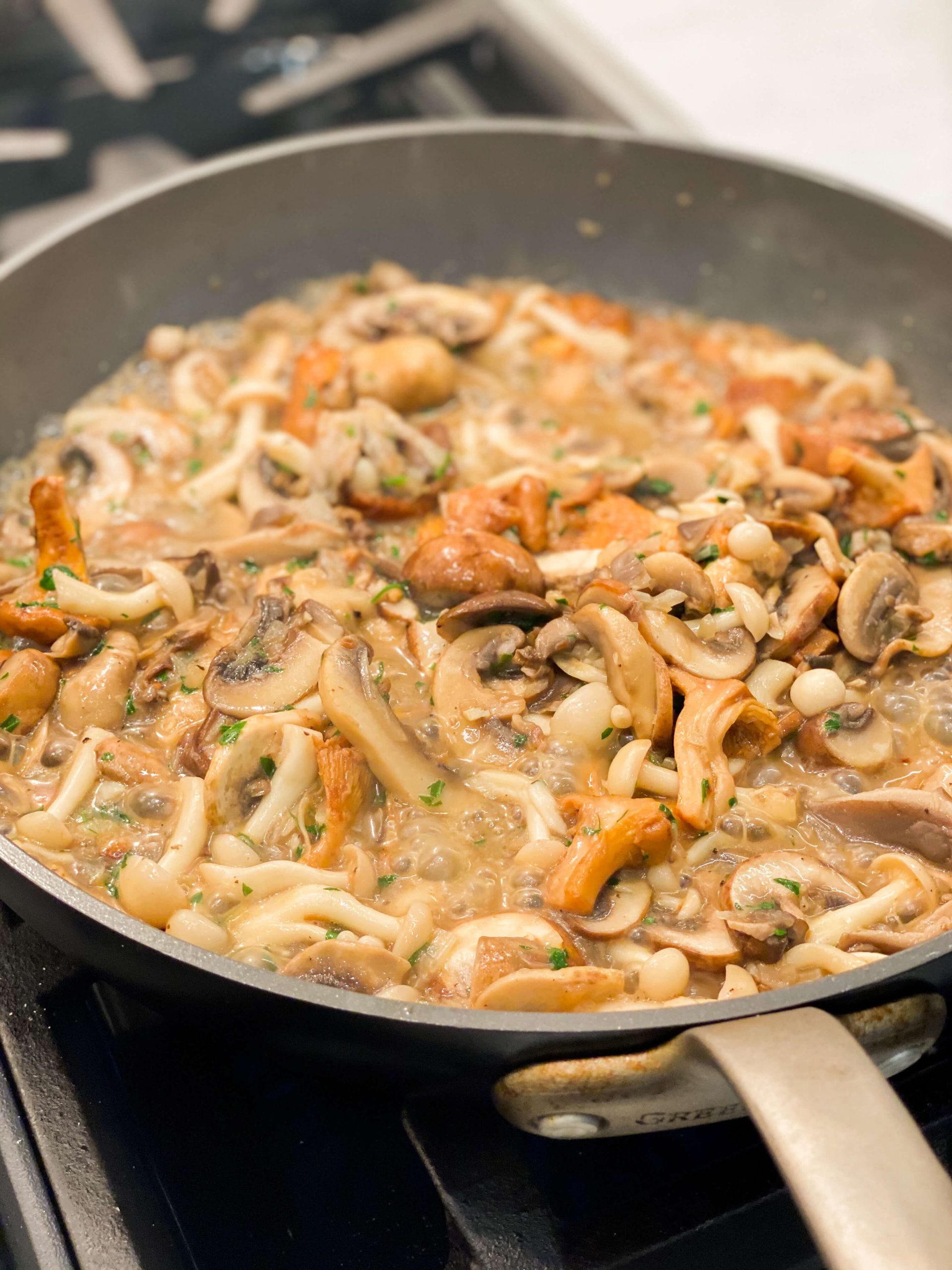 mushrooms cooking with pasta water, garlic and parsley 