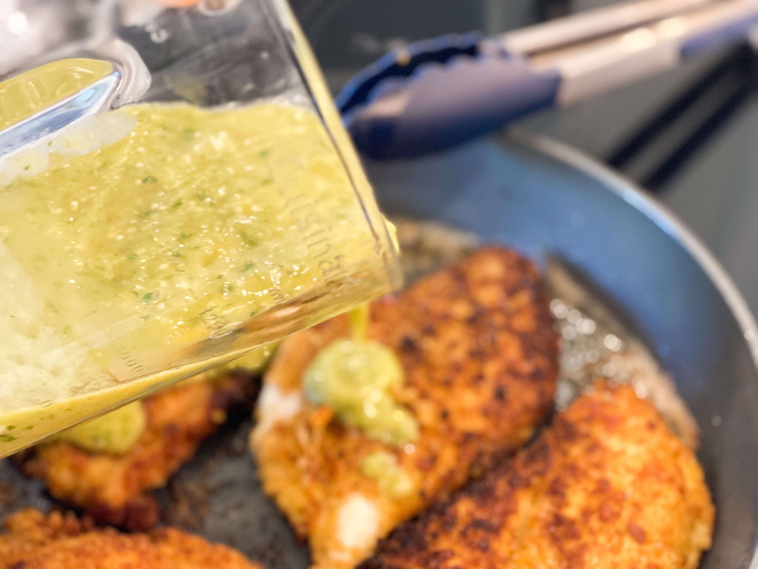 tomatillo salsa poured on top of breaded chicken 