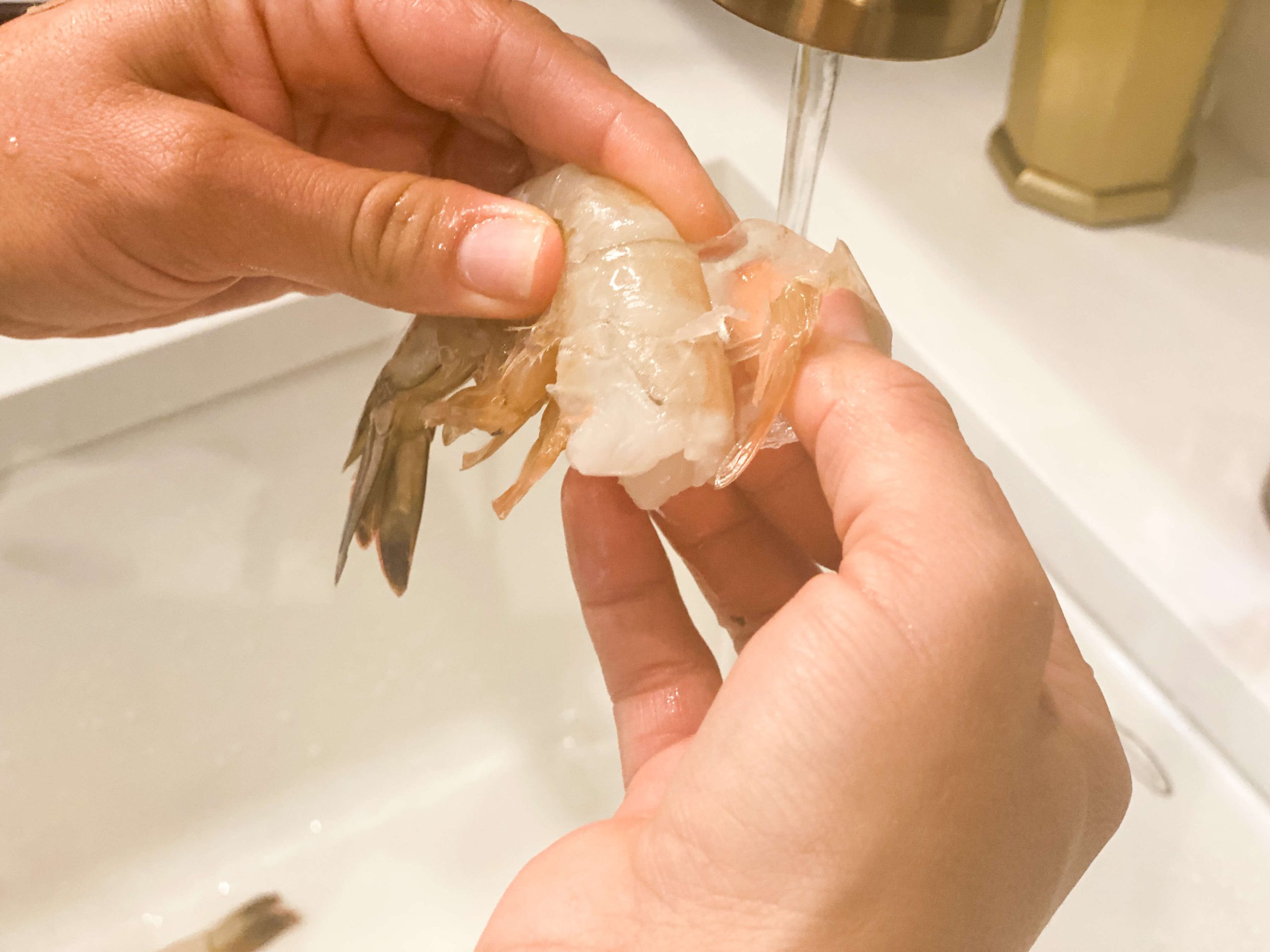 Finger sliding in the shrimp to remove shell