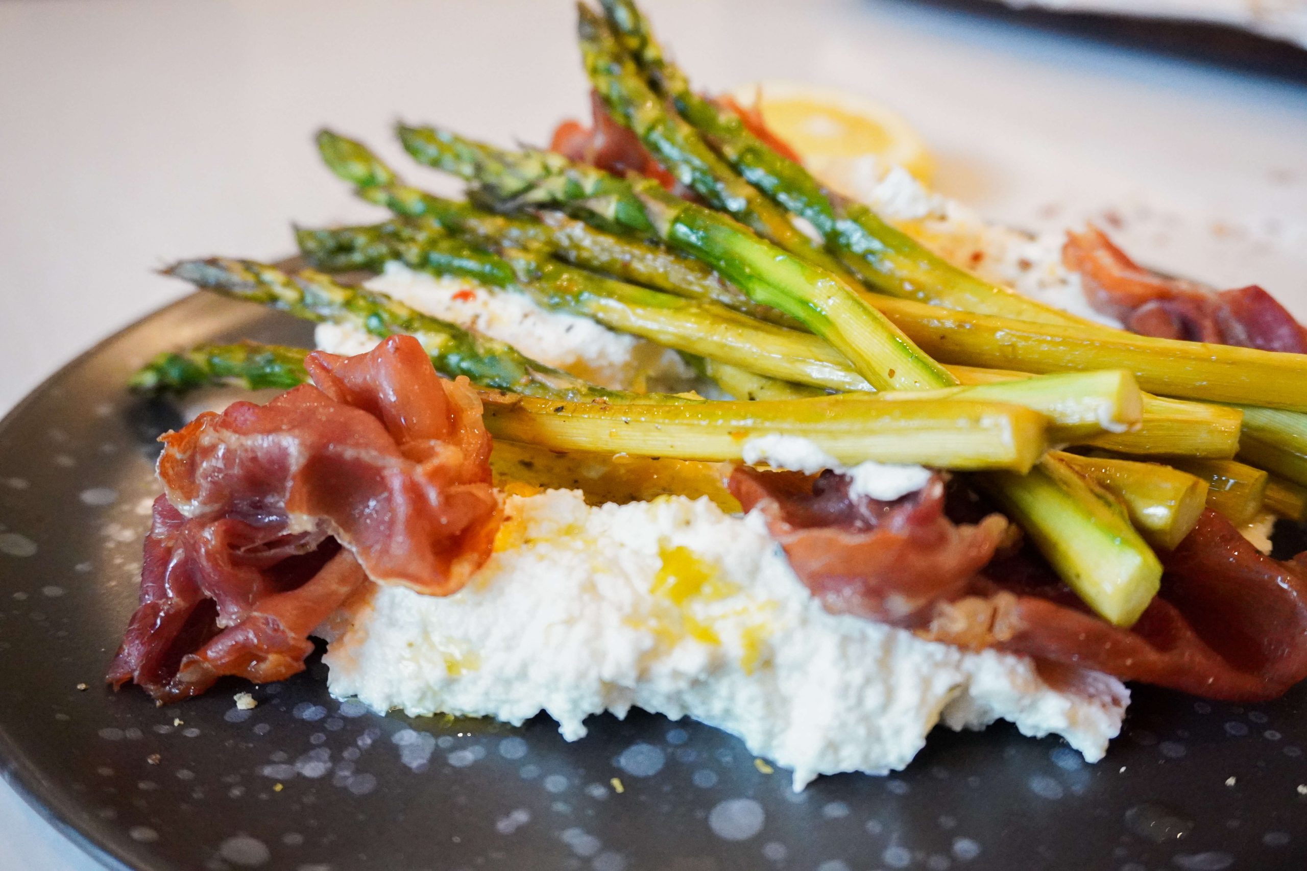 plated whipped feta with asparagus and crispy prosciutto with lemon and olive oil