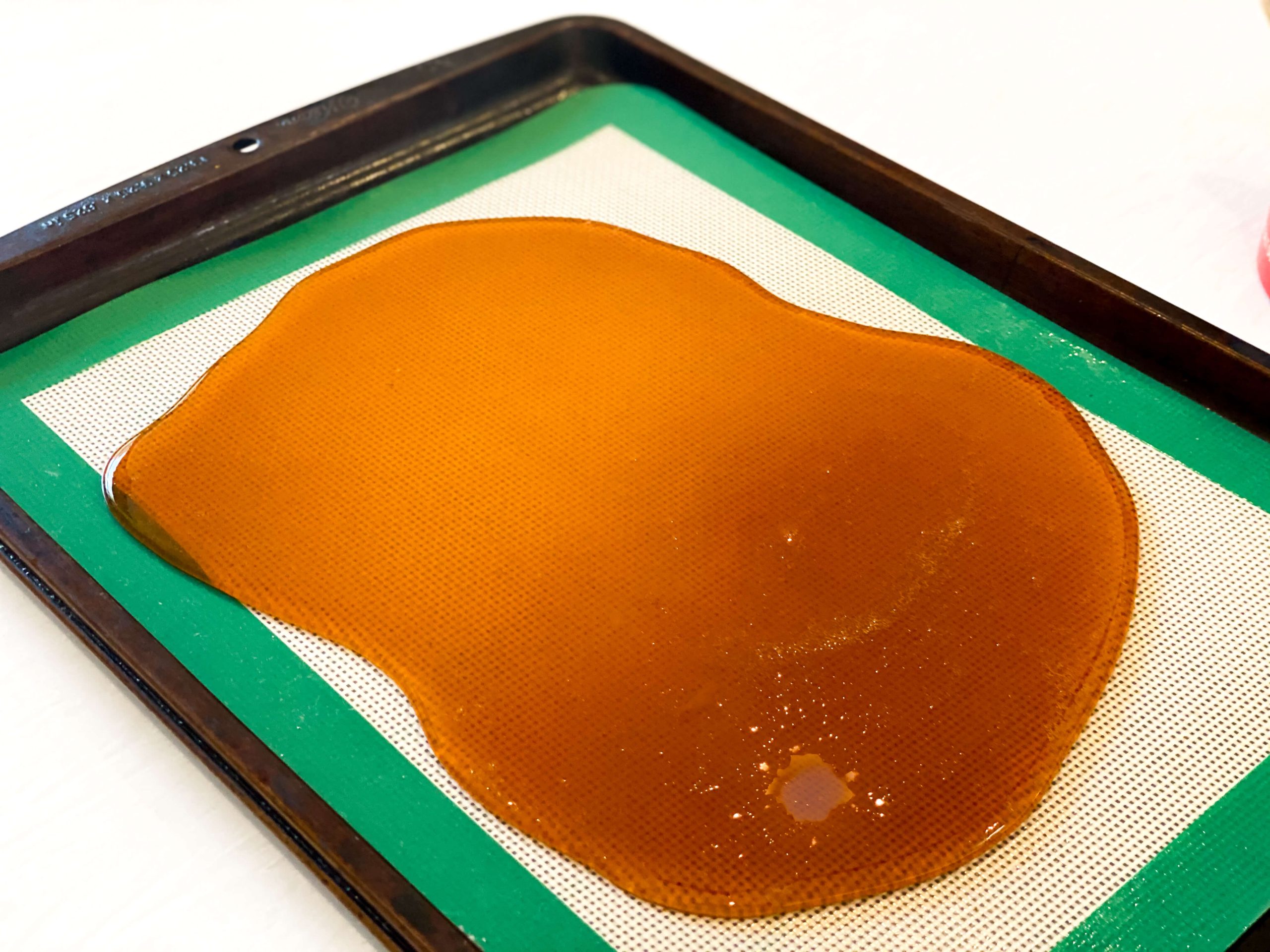 amber colored sugar candy poured over a silicone mat