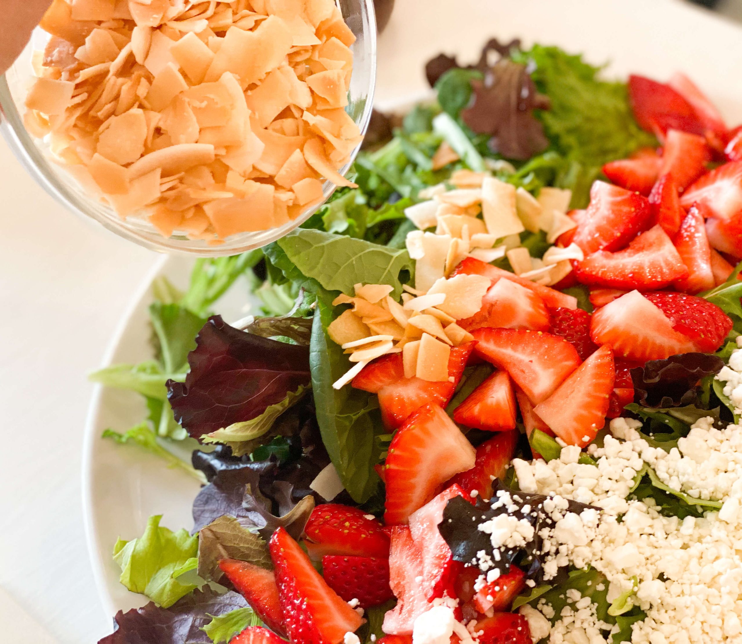 strawberries, goat cheese and coconut on salad