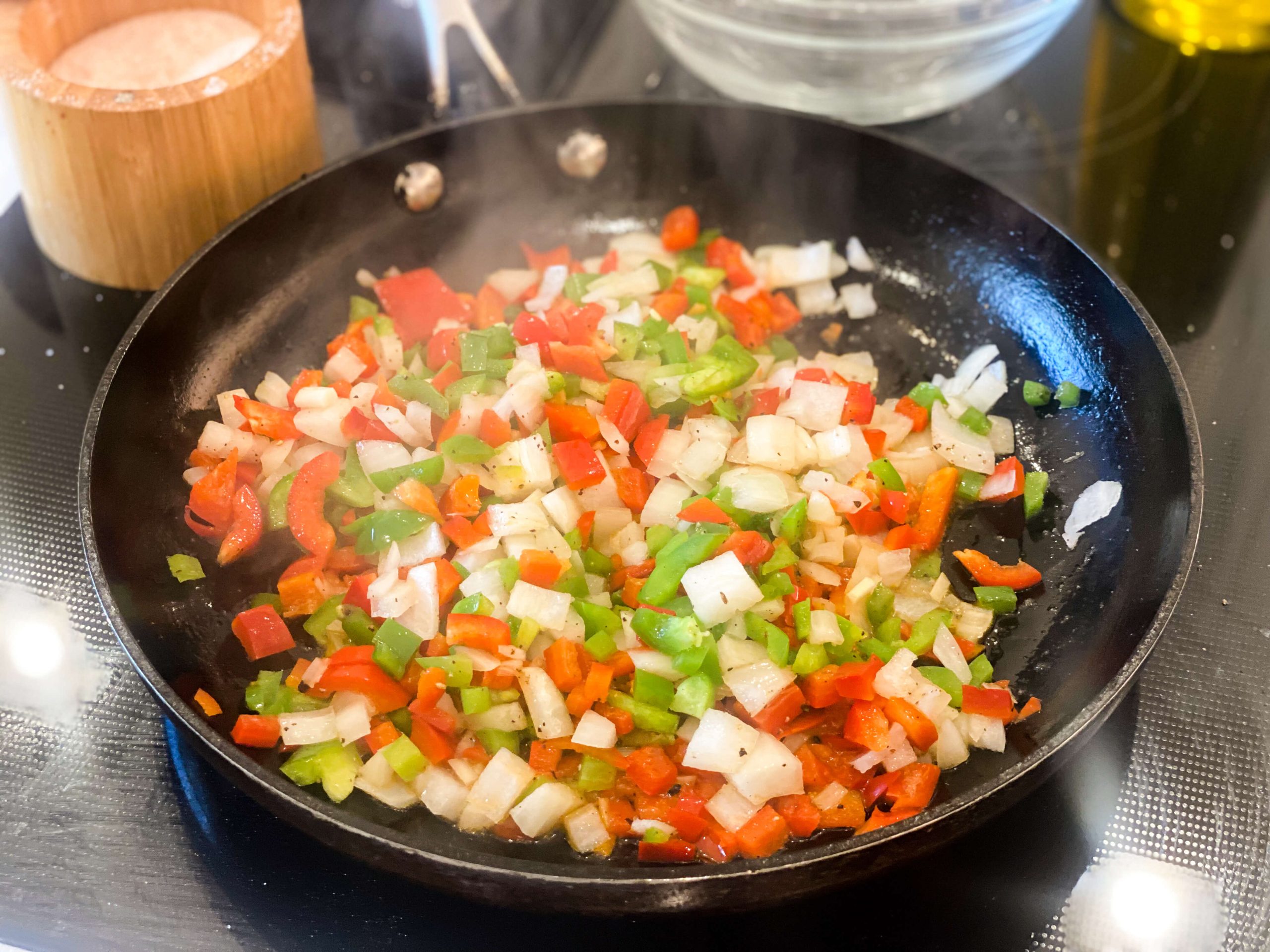 green and red bell peppers and onions sautéing seasoned with salt and pepper. 