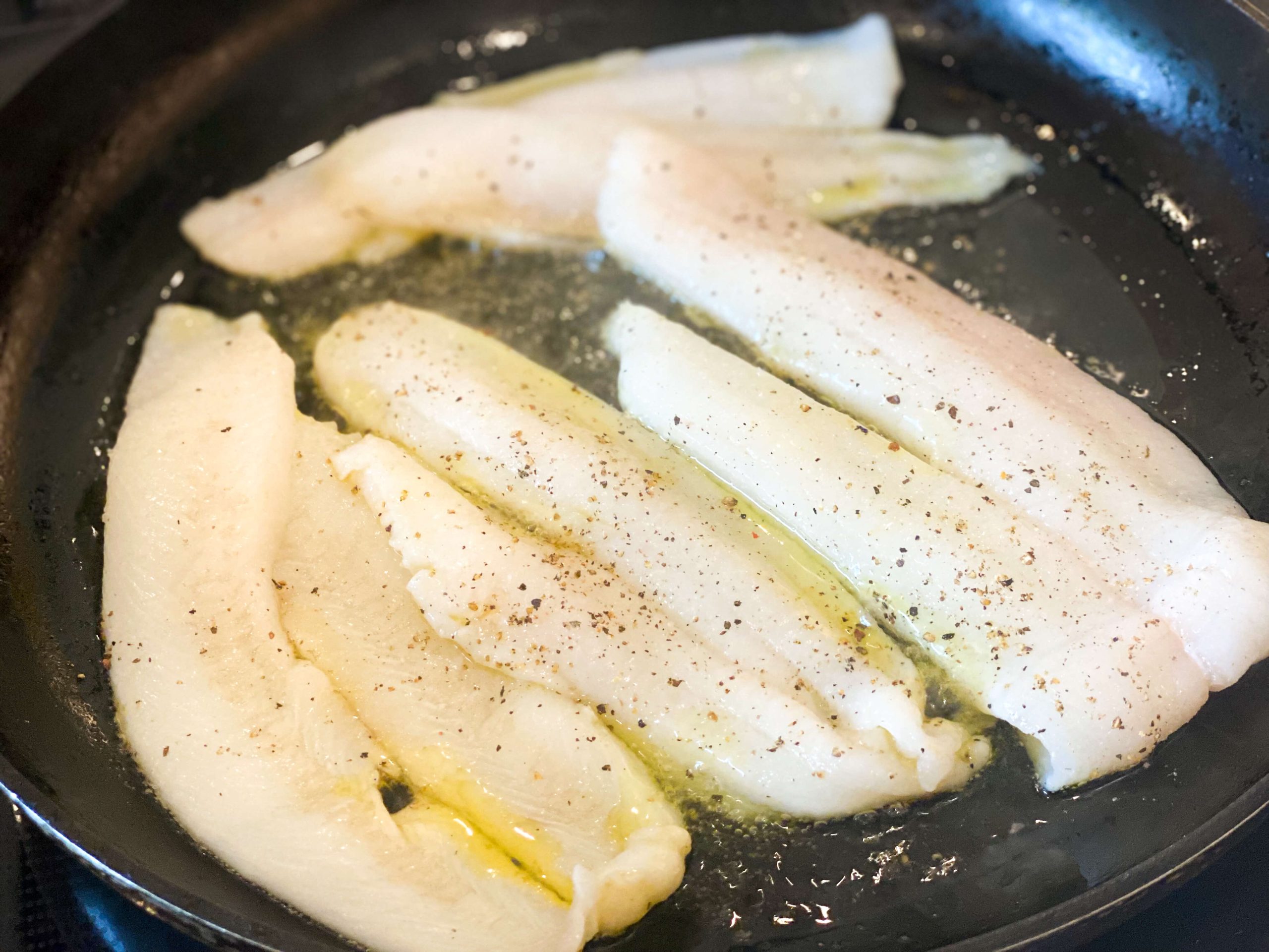Filet of sole in frying pan with butter and vinaigrette 