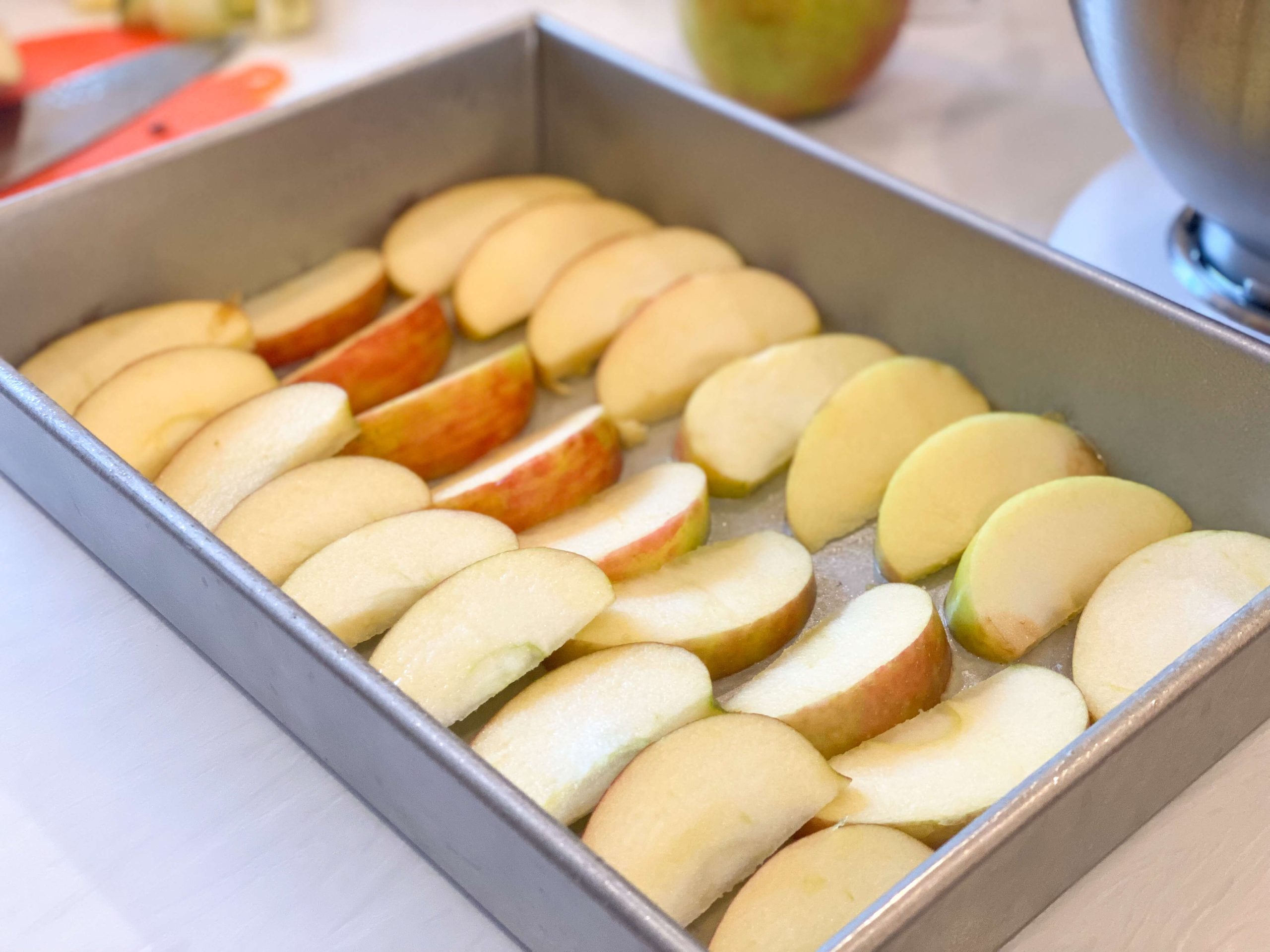 apples arranged in the bottom of the cake pan
