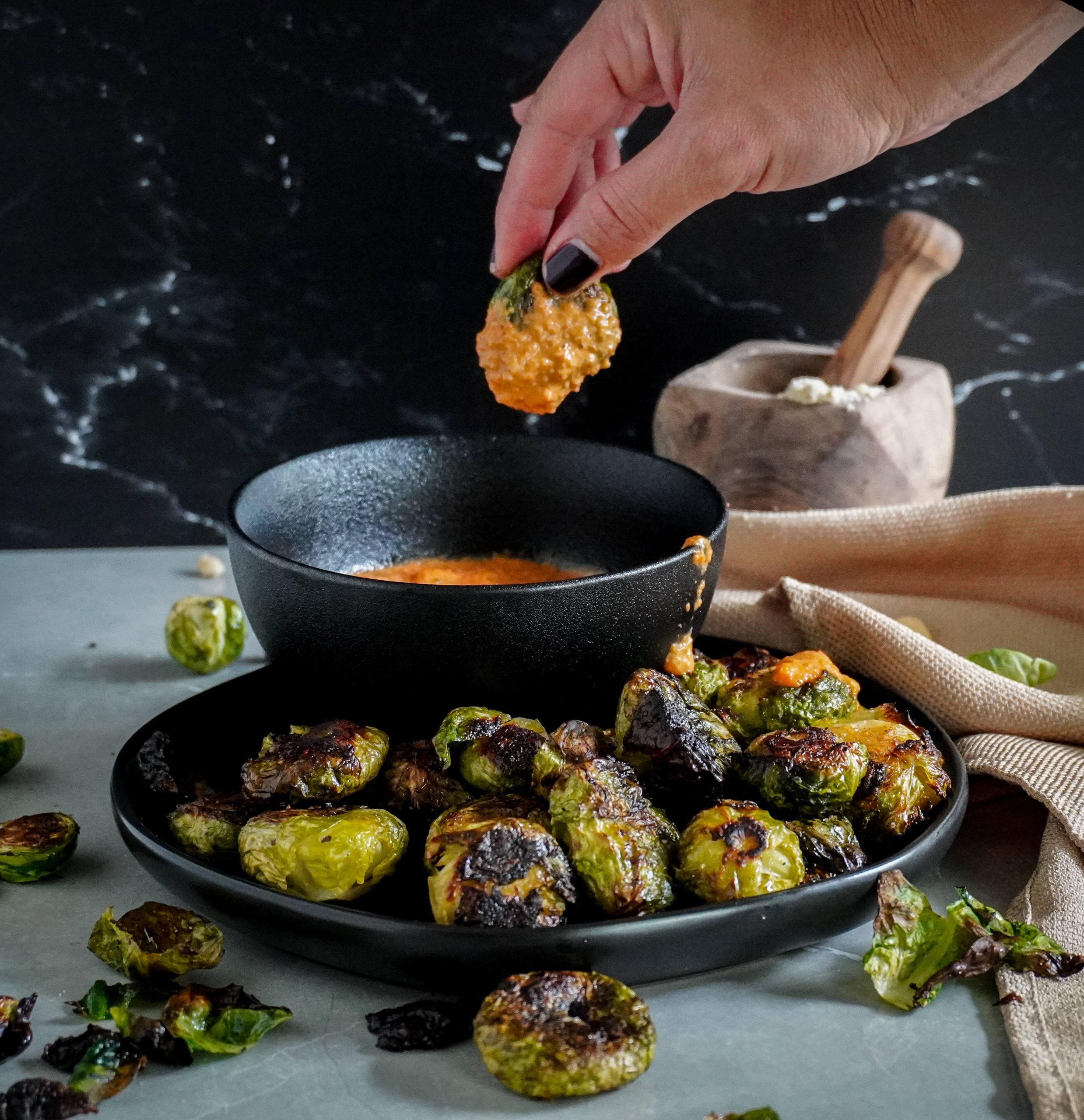 dipping one of the Brussel sprouts into the romesco sauce. 