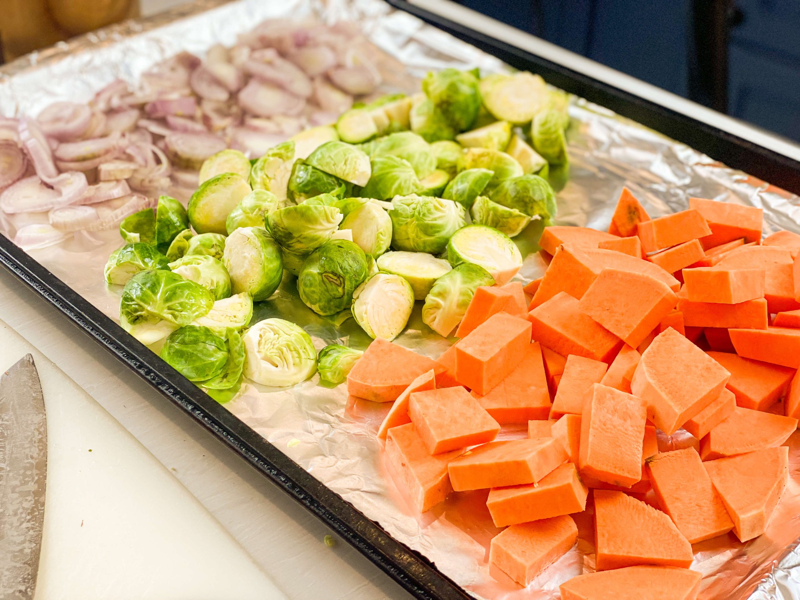 vegetables cut and lined up on baking sheet