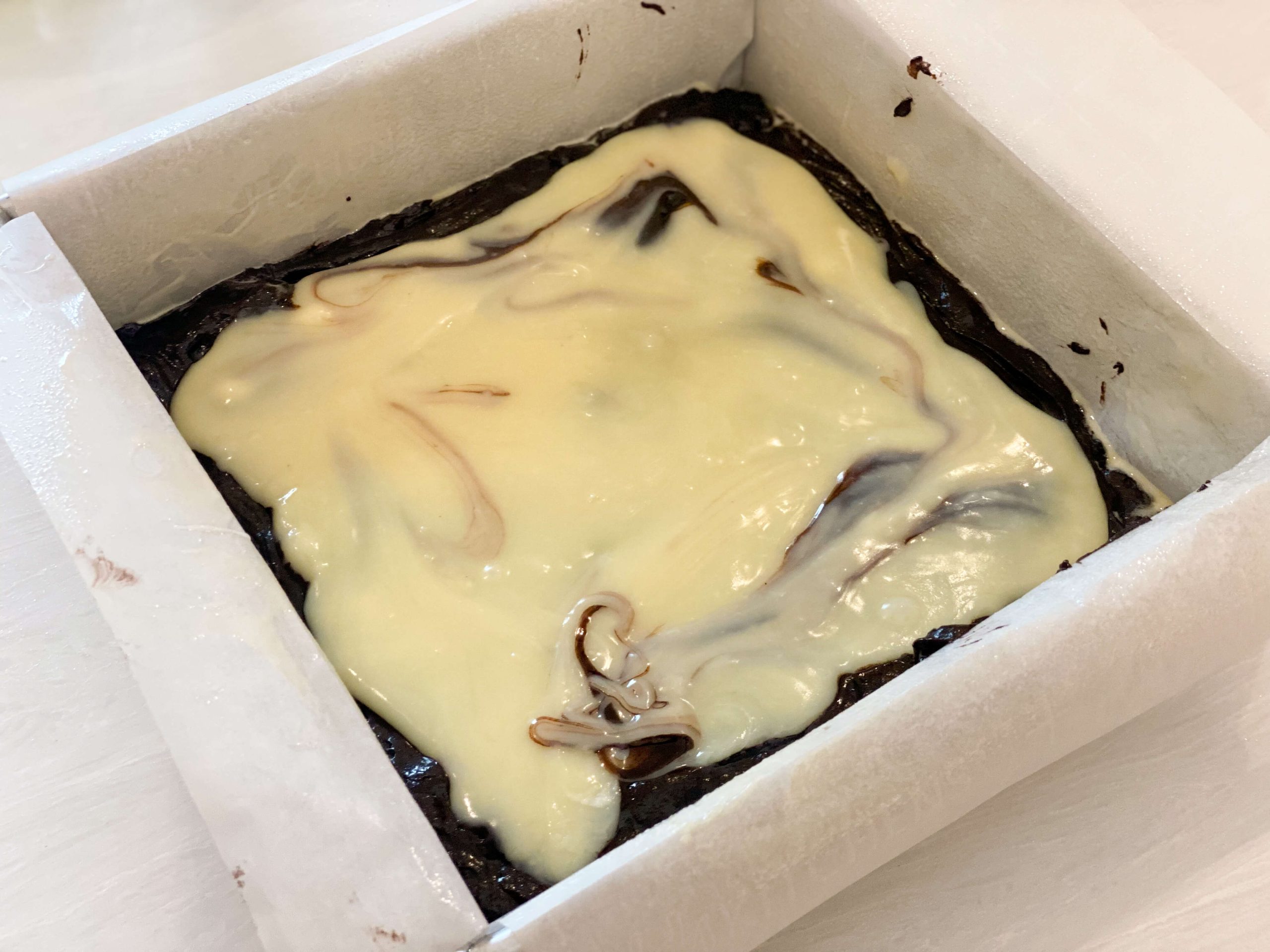 white chocolate on top of half of the brownie batter