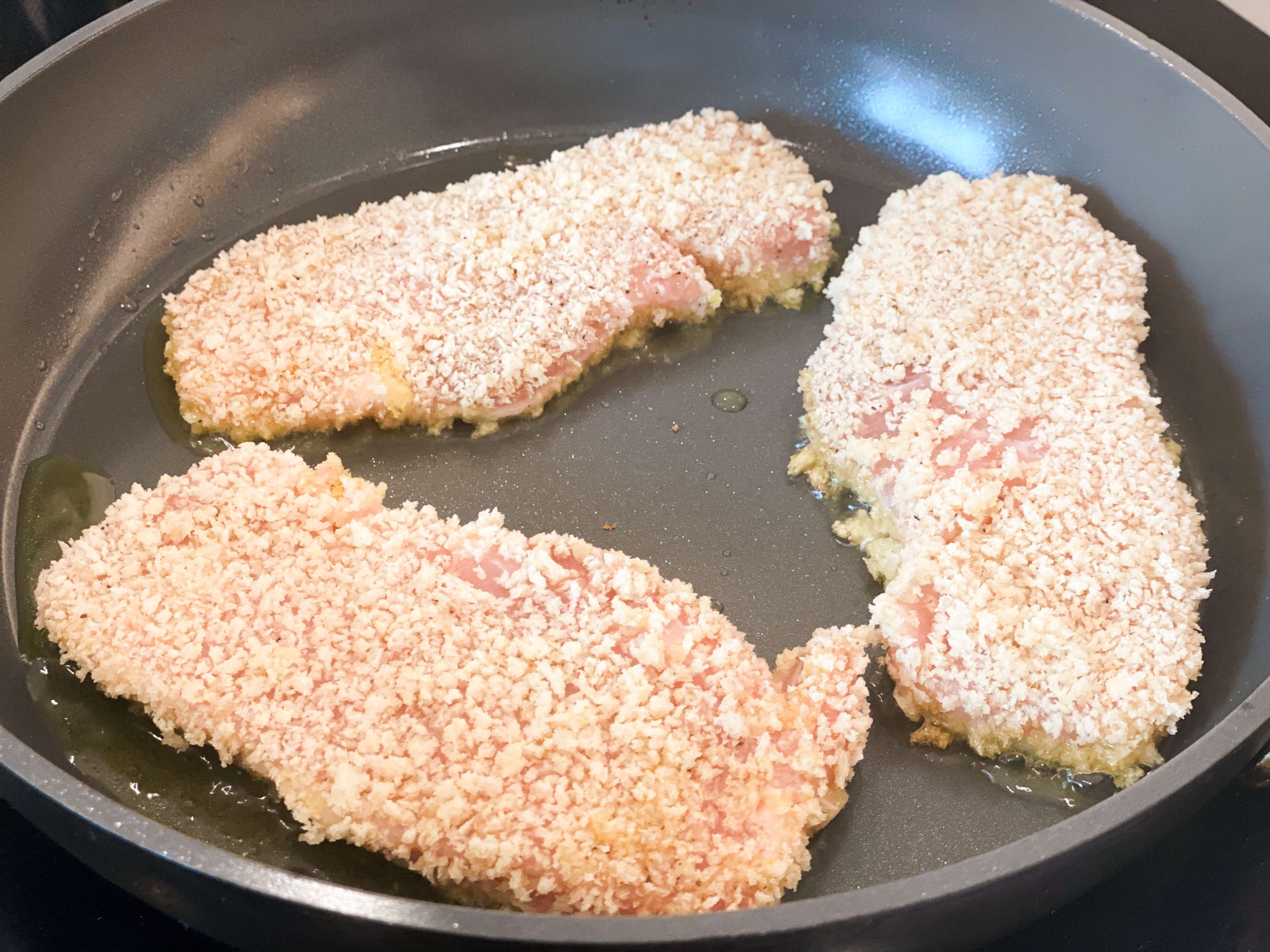 pork chops frying in pan