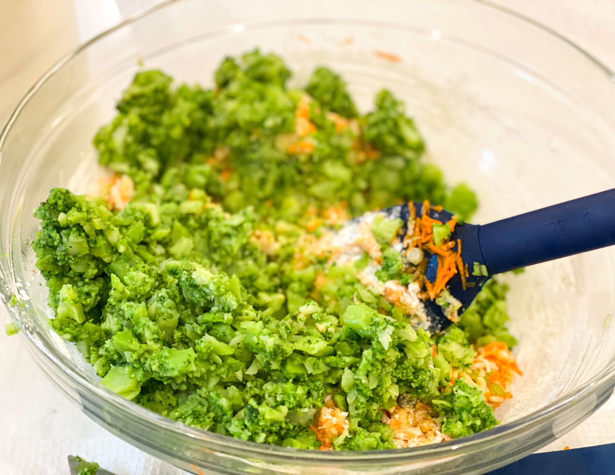 brocoli tossed into flour and carrot mixture