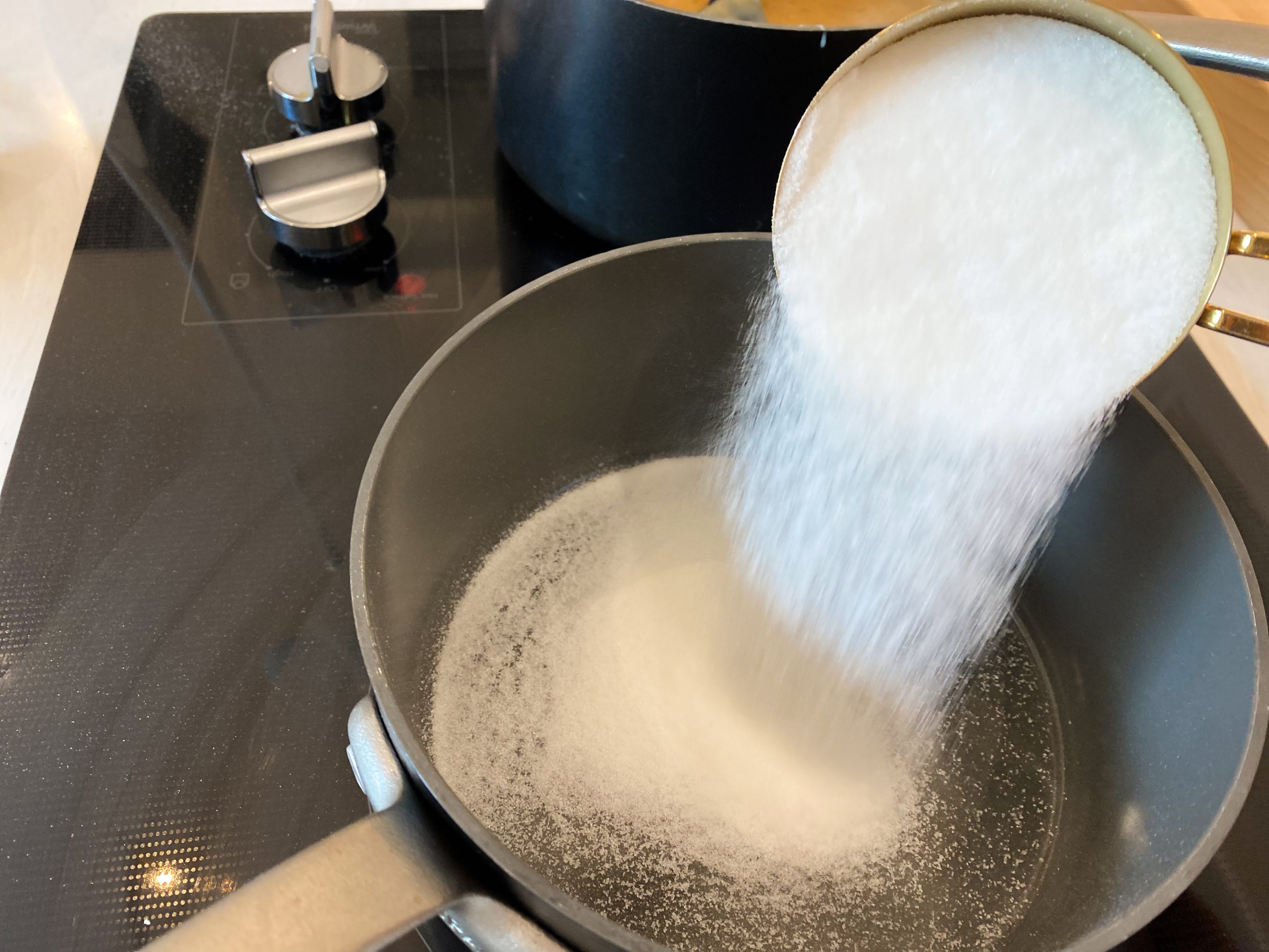 sugar being poured into pot