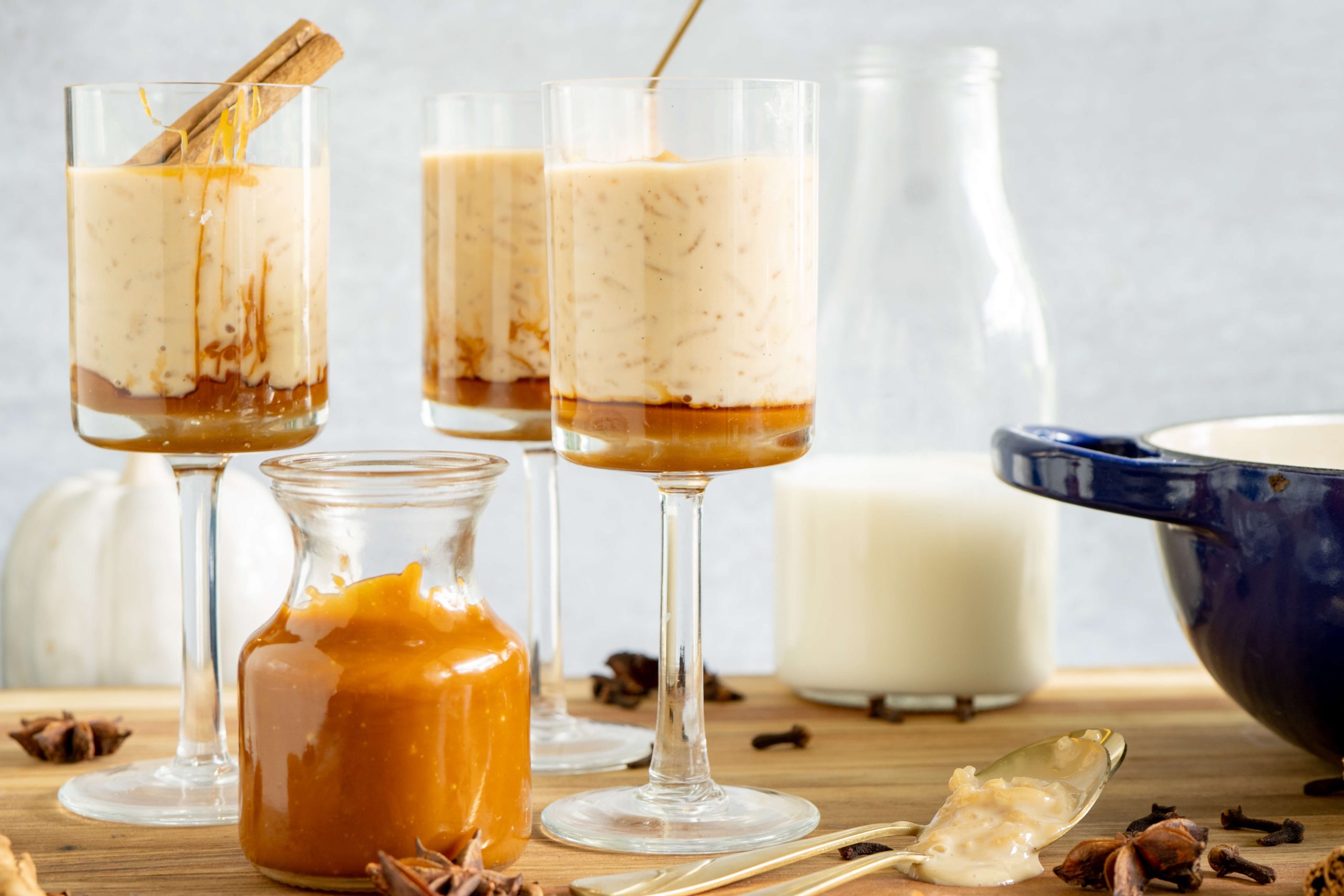 caramel sauce and rice pudding served in tall glasses