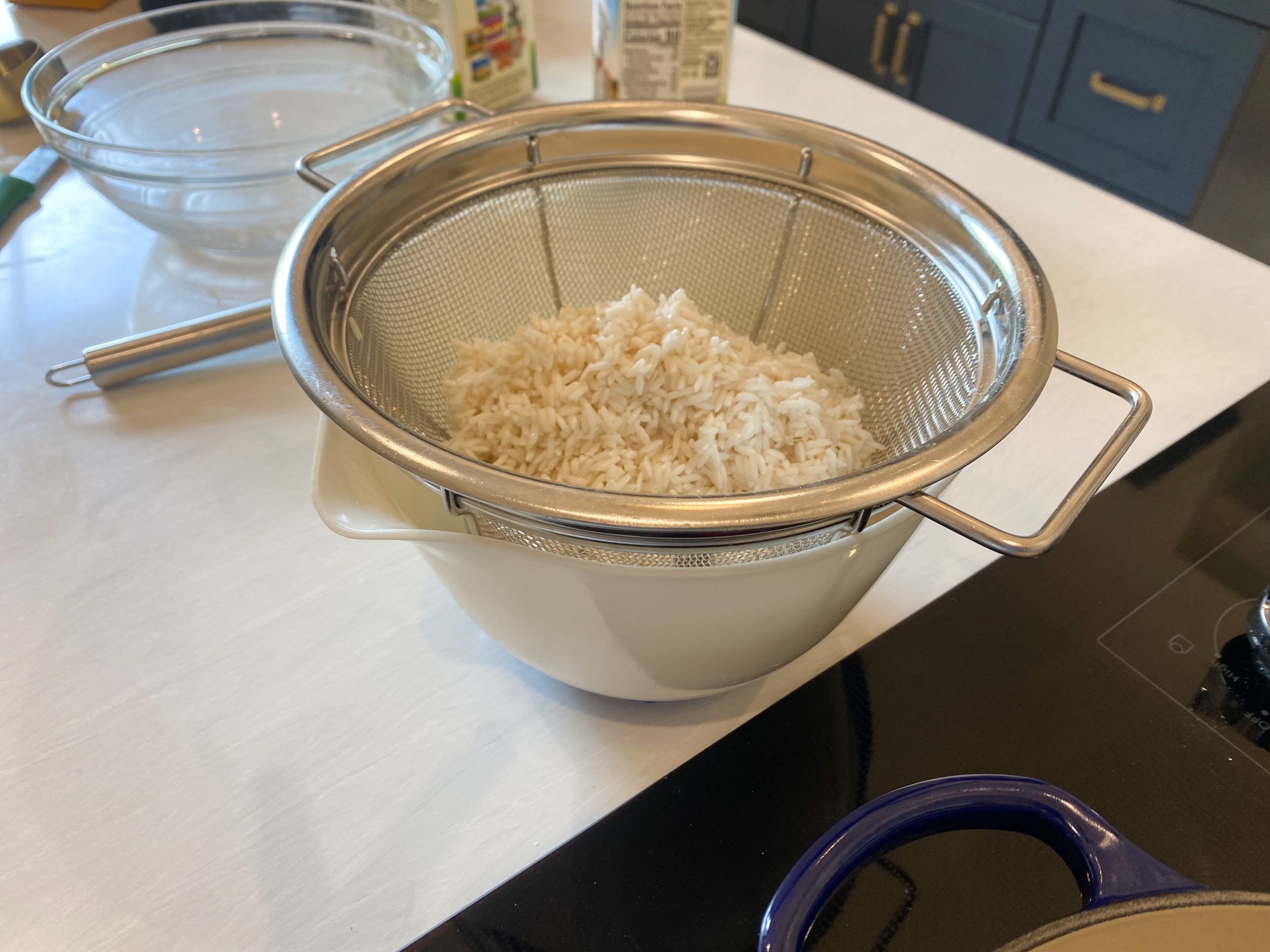 strained rice with water reserved in a bowl for later use