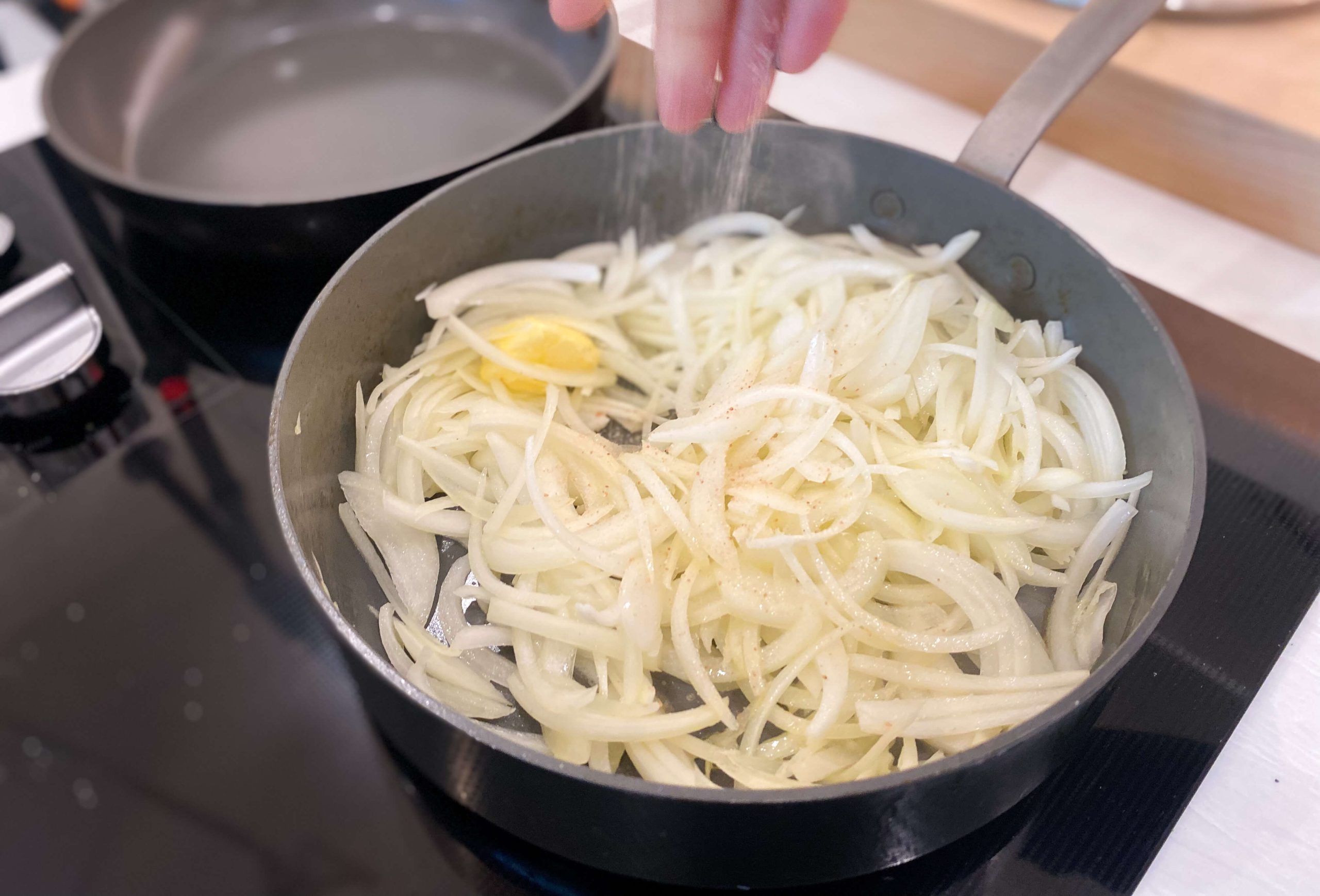 onions cooking with butter, oil and seasoned with salt and pepper