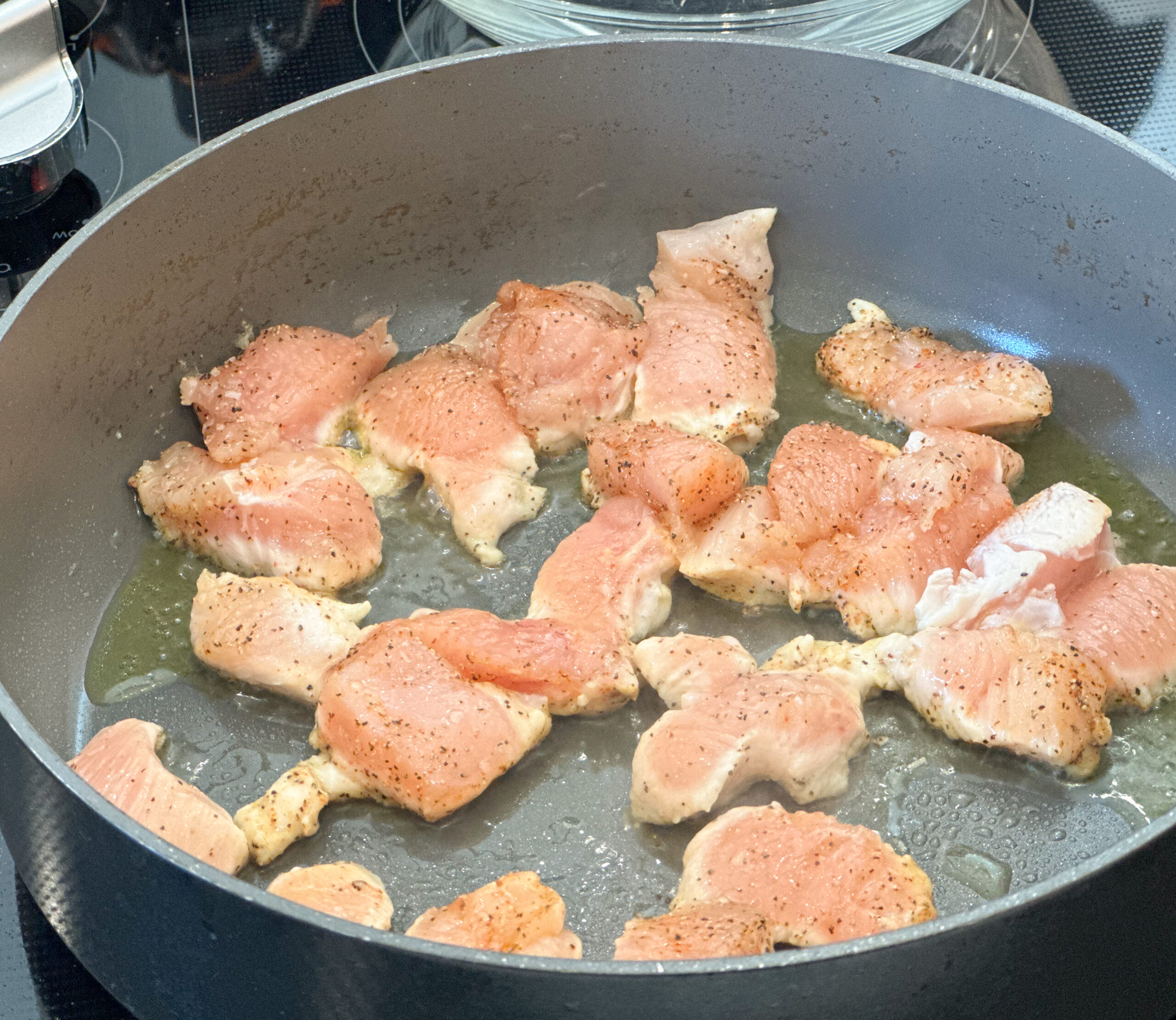 chicken cooking in heated pan